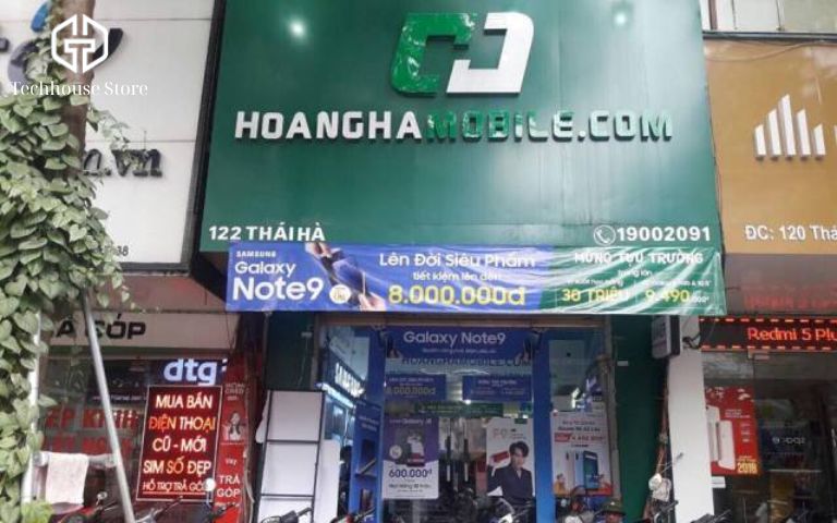 Top 11 cửa hàng iPhone uy tín ở Đống Đa - Hà Nội (2025) Cửa hàng Hoàng Hà Mobile màu xanh đặc trưng tại 122 Thái Hà với các quảng cáo khuyến mãi.