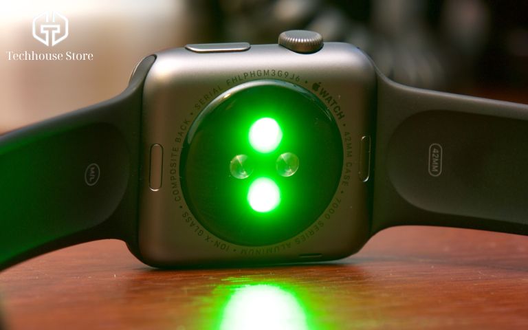 Hướng Dẫn Cách Kiểm Tra Apple Watch Cũ Chi Tiết: Góc Nhìn Chuyên Gia (2026) Mặt sau Apple Watch với cụm cảm biến nhịp tim đang phát sáng đèn xanh lục, thể hiện tình trạng hoạt động tốt.