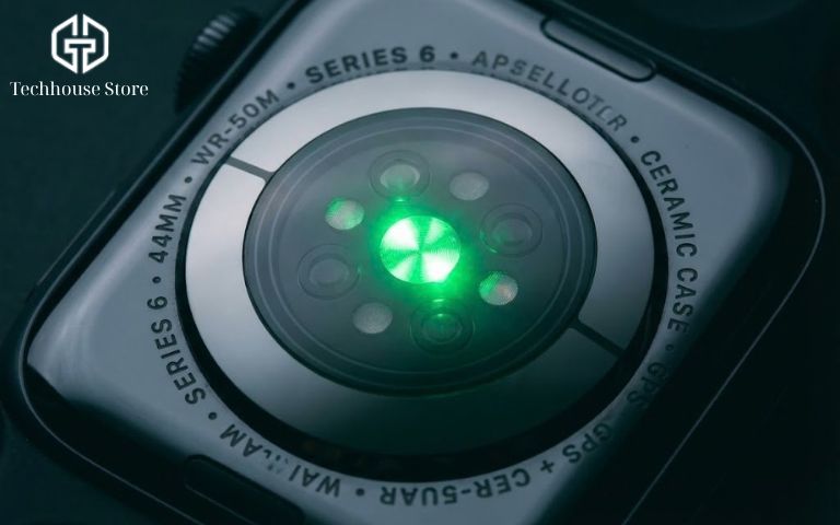 Cách kiểm tra Apple Watch chính hãng: Check Serial/IMEI, iCloud và Bảo hành (2026) Mặt lưng gốm của Apple Watch với cảm biến nhịp tim đang phát sáng đèn xanh lá cây mạnh mẽ.