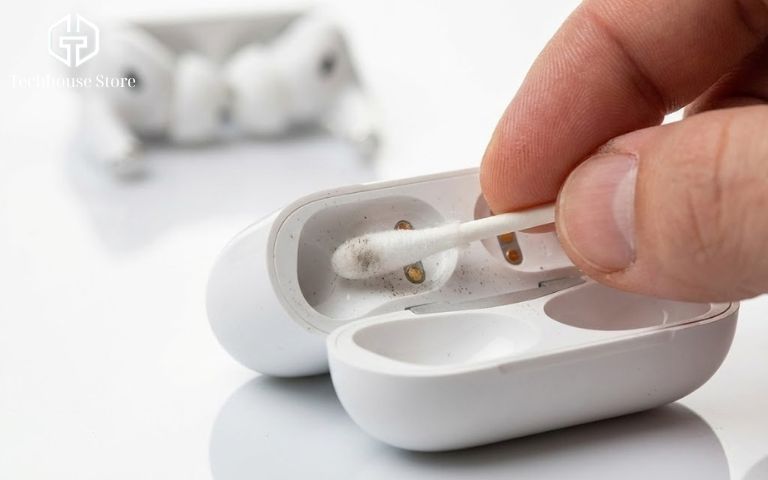 Cách Kiểm Tra Pin AirPods (Tất Cả Các Dòng) Chính Xác Nhất 2026 Cận cảnh dùng tăm bông vệ sinh điểm tiếp xúc kim loại bên trong hộp sạc AirPods.