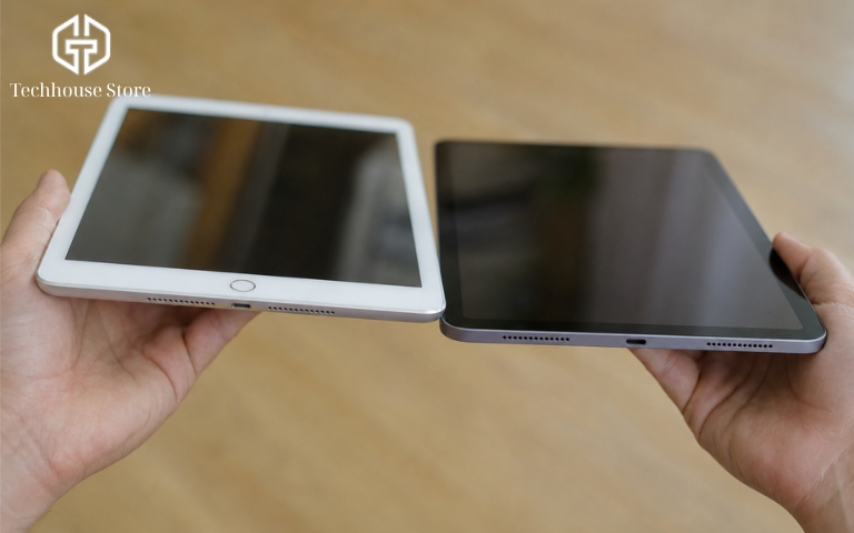 So sánh iPad Air 4 và iPad Gen 9: đâu là lựa chọn phù hợp với bạn? Cận cảnh một người đang cầm iPad Gen 9 với nút Home viền dày và iPad Air 4 có thiết kế cạnh phẳng không nút Home.