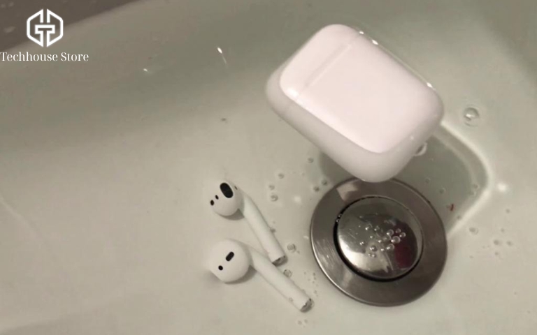 AirPods Pro có chống nước không? Mức chống nước từng đời và cách xử lý khi bị vô nước Tai nghe AirPods thường và hộp sạc nằm trong bồn rửa có nước.